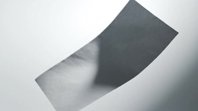 A single sheet of paper floats gently against a clean, bright background