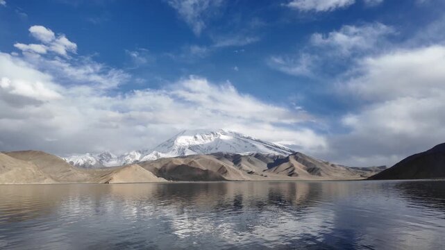 Scenic view of Muztagh Ata snow mountain reflection in dark waters of Karakul Lake Xinjiang China