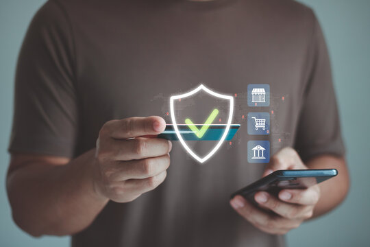 Secure online payment concept. Customer holding credit card and smartphone beside digital shield icon, representing payment protection, mobile banking security, ecommerce safety, financial technology.