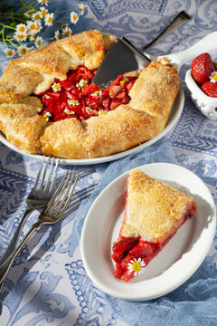 Fresh strawberry galette with a slice on a plate