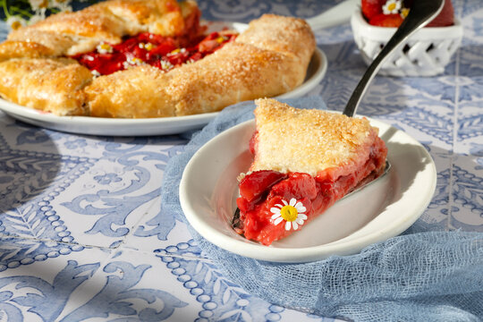 Slice of rustic strawberry galette in summer sun