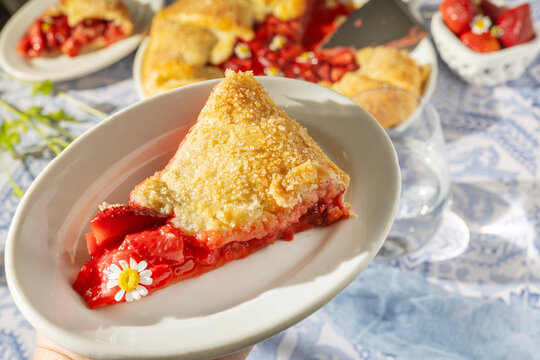Holding a fresh slice of rustic strawberry galette