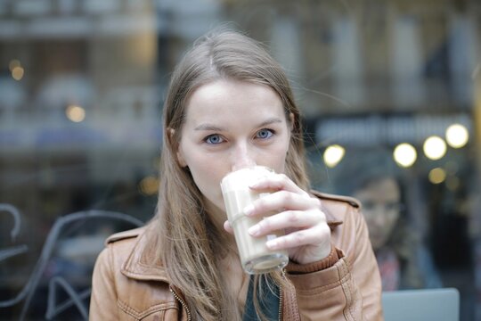 Woman with blue eyes drinking coffee at a cafe