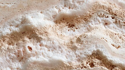 Obraz premium Close-up of a textured surface. the surface appears to be made of a light-colored material, possibly sand or gravel. the texture is rough and uneven, with small bumps and grooves scattered throughout.