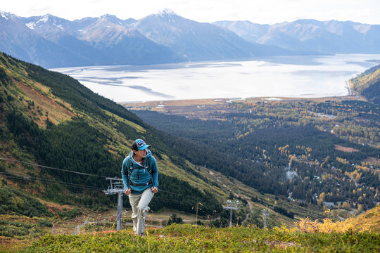 Female hiker ascending a vast mountain landscape