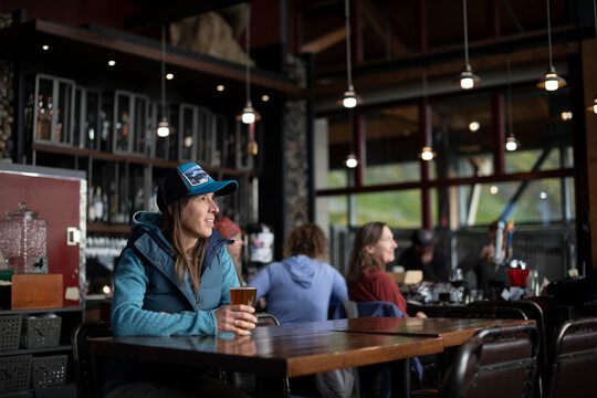 Woman in a hat relaxing with a pint of beer at the tram house bar