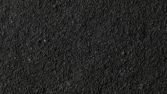 Coarse black sand or dark granular soil texture background
