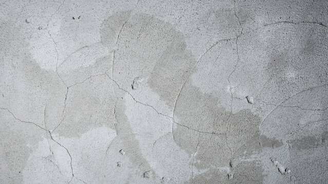 Close-up macro view of weathered gray concrete wall with fine cracks and uneven patchy texture, industrial surface background