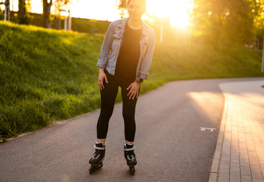 Woman Rollerblading Through Park At Sunset