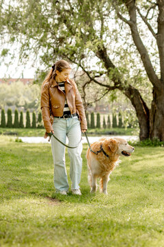 Girl Walking With Golden Retriever Dog Near The Lake