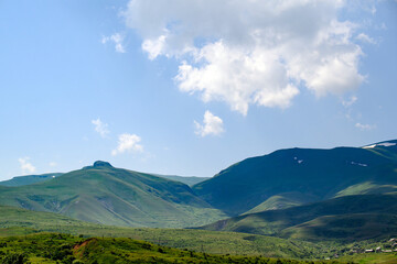 Obraz premium Rolling green hills with valley and distant ridge