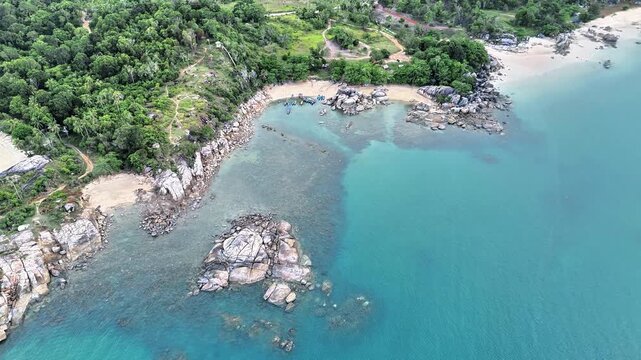 Aerial Drone View of Turun Aban Beach Bangka Showcasing Granite Rock Formations Crystal Clear Turquoise Waters Tropical Coastline and Hidden Coves