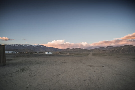 The high-mountain village of Bulunkul in the Tien Shan Mountains in the Pamirs of Tajikistan one-story houses of local residents in the evening against the backdrop of mountain ranges