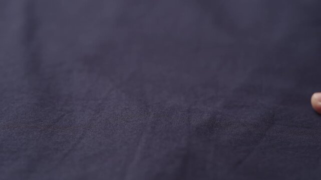 Slow motion man hand checking blue cotton shirt cloth
