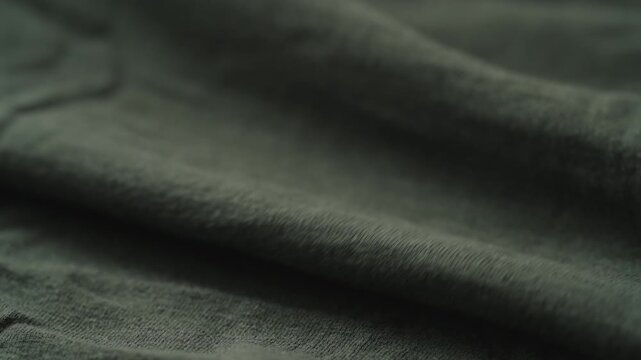 Slow motion man hand checking green linen jersey cloth