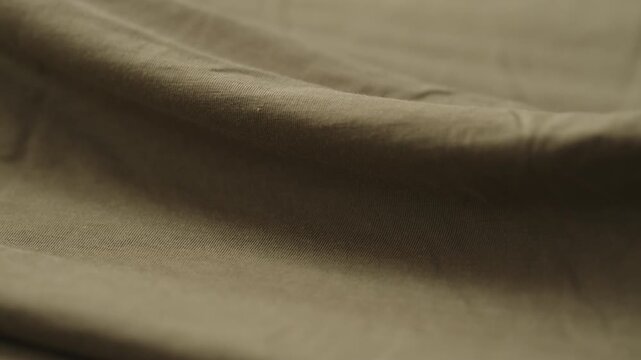 Slow motion man hand checking green cotton jersey cloth