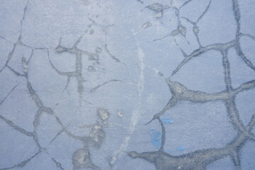 Weathered blue concrete surface featuring cracked paint and distressed texture, ideal as a rustic abstract background for design projects. © Sije
