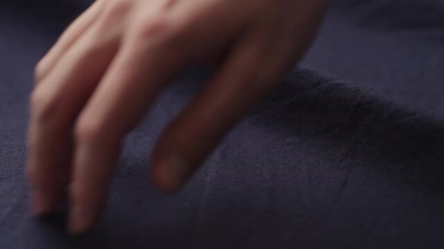 Slow motion man hand checking blue cotton shirt cloth