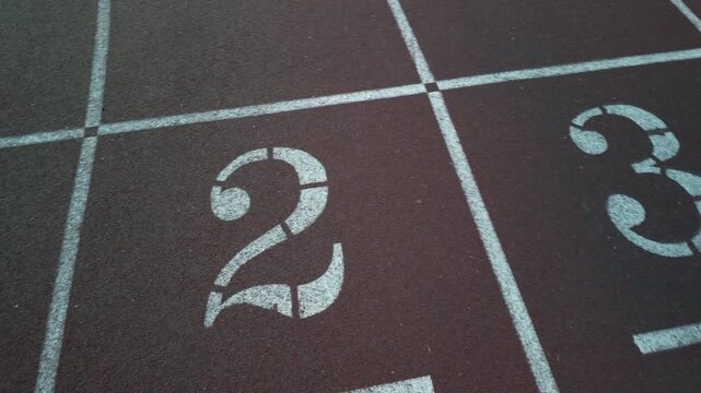 textured, reddish brown surface of a professional running track, sports, athletics, and fitness themes, storytelling about competition, training