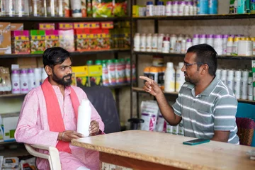 indian farmer and fertilizer shop owner discussing about best product at shop © PRASANNAPIX