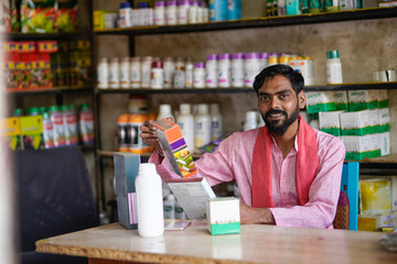 Fototapeta premium Indian farmer purchasing fertilizers or pesticides at shop