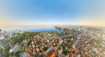 Fototapeta premium Antalya, Turkey. Kaleici Old Town terracotta rooftops sweeping toward the Mediterranean coastline, aerial panoramic view on a bright summer morning