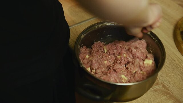 Mixing minced meat with butter in saucepan close up