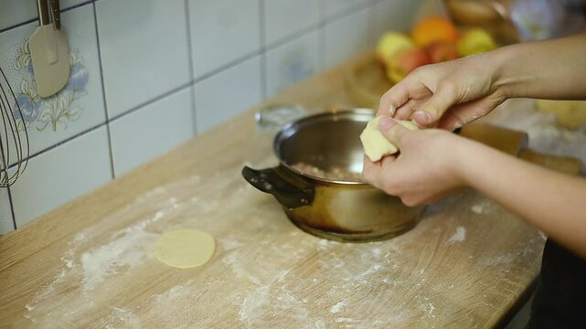 Pinching and folding dough to make homemade pelmeni