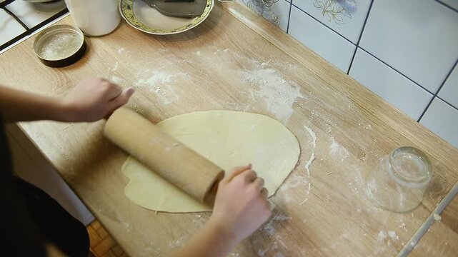High angle view of rolling out dough on wooden board