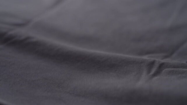 Slow motion man hand checking blue cotton jersey cloth