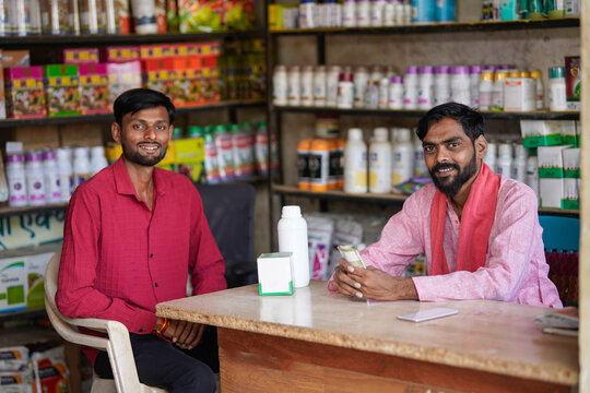 two indian people sitting at fertilizer shop