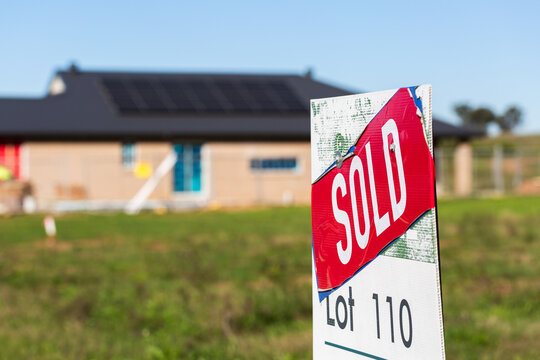Land lot SOLD sign infront of house under construction