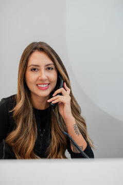 Female receptionist taking a phone call on the front desk