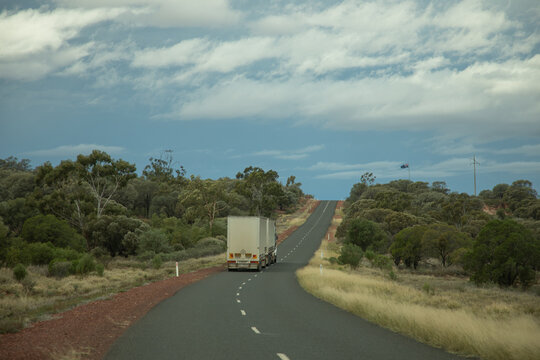 Prime mover pulling two curtain sided trailers going up a jump-up