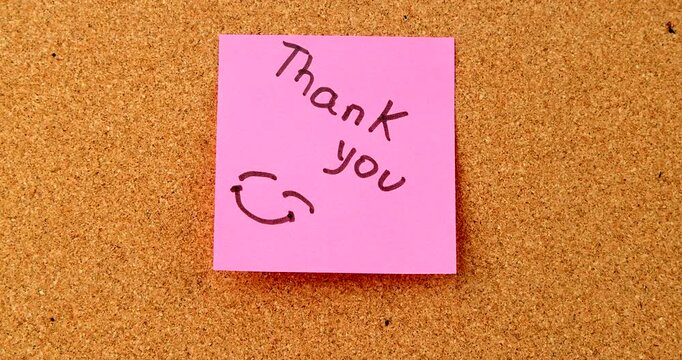A bright pink sticky note with the handwritten text Thank You and a simple drawn smiley face icon, symbolizing kindness and positive feedback today.