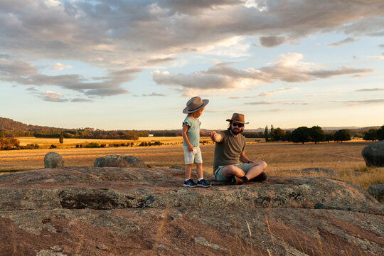 Rocky boulders in rural landscape with little girl pulling dad with her