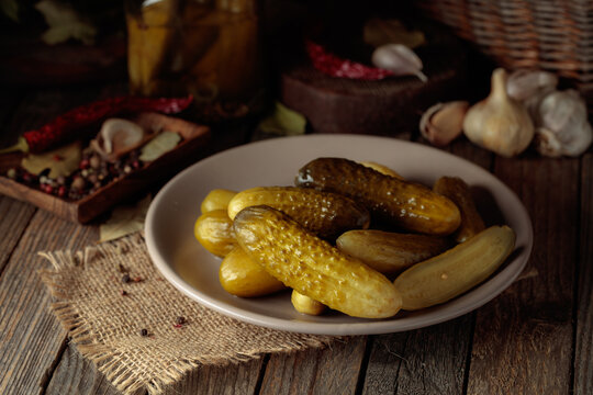Homemade canned gherkins on a rustic wooden background.
