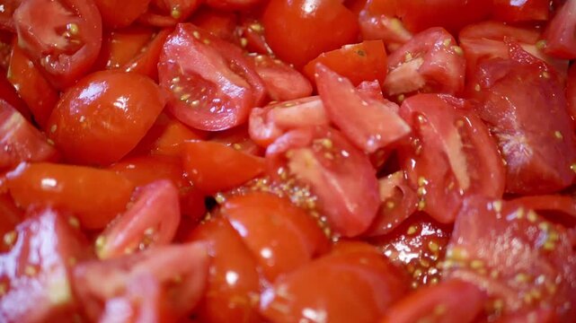Close up view of chopped red tomato pieces for salad preparation or cooking sauce. The ripe red vegetable chunks glisten with juice in a pile. This represents healthy fresh ingredients.