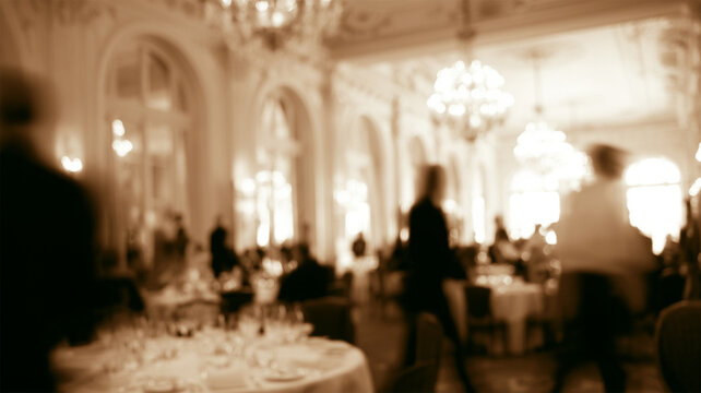 Blurred luxury restaurant interior with elegant chandeliers and dining tables, abstract hospitality background with warm ambient lighting
