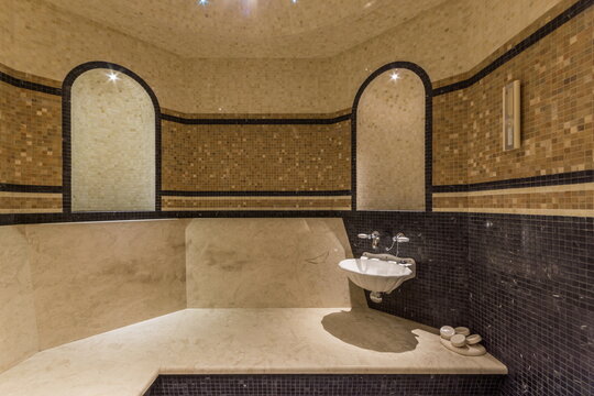 Turkish bath hamam, decorated with mosaic tiles in Oriental style. A wide bench and an original sink.