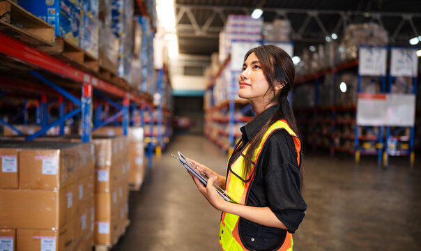 Portrait of female staff with holding clipboard working in warehouse, Industrial and industrial workers concept.