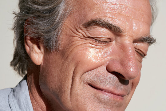 Elderly man portrait close up smiling with closed eyes, textured skin, silver hair, natural light, warm expression, detailed wrinkle and cheekbone study