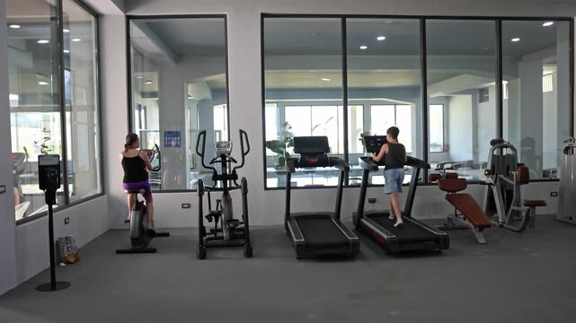Beautiful view of modern fitness gym with cardio equipment and people exercising indoors. Crete. Greece. 