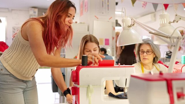 Teacher helping students at sewing workshop