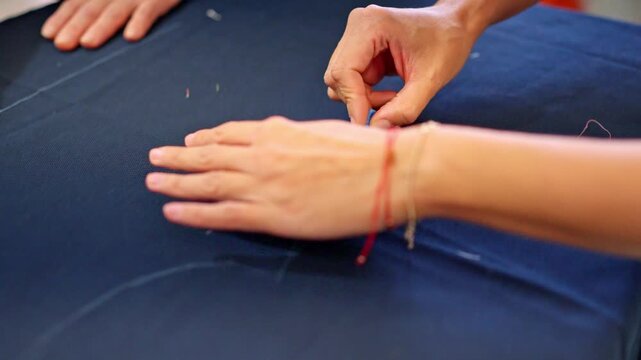 Tailor hands drawing a sewing pattern with chalk