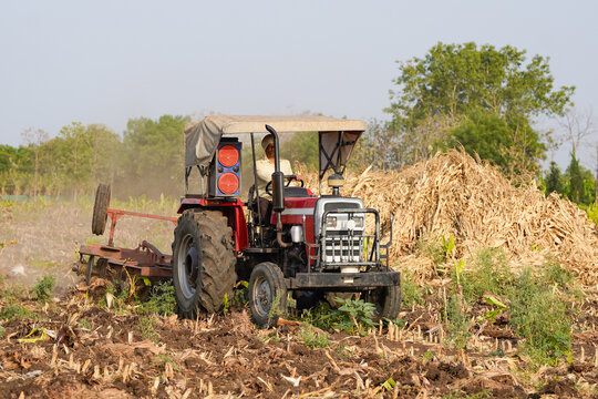 Indian farmer working with tractor at agriculture field
