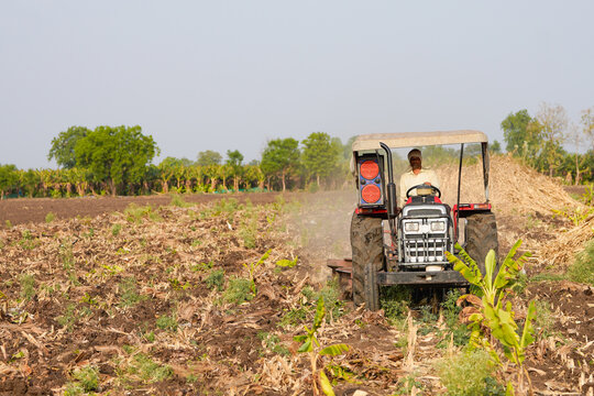 Indian farmer working with tractor at agriculture field