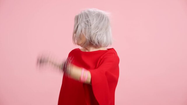 Stylish senior woman with grey hair dancing