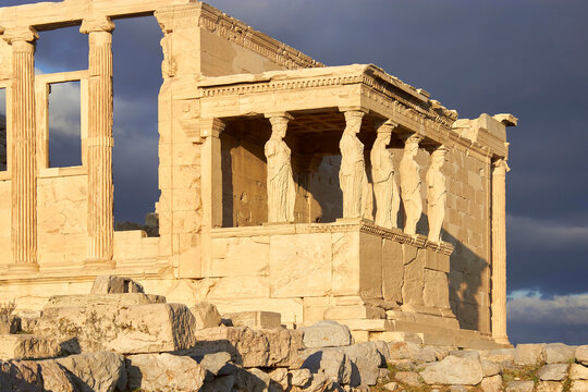 Ancient Caryatid statues of the Erechtheion temple under a dramatic stormy sky, Acropolis of Athens in Greece
