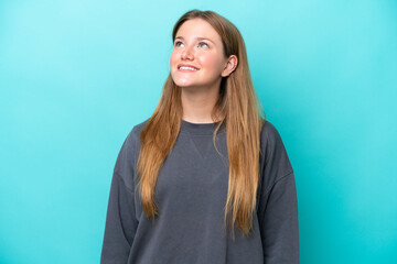 Fototapeta premium Young caucasian woman isolated on blue background thinking an idea while looking up